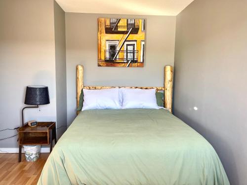 1 dormitorio con 1 cama y una foto en la pared en Top Floor Riverfront Condo with Stellar Sunsets!, en Fort McMurray