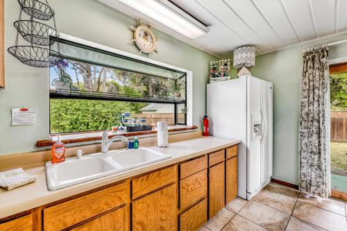 a kitchen with a sink and a refrigerator at Mendocino Dunes - Distant Shores in Fort Bragg