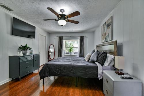 a bedroom with a bed and a ceiling fan at South Asheville home with hot tub just 11 miles to downtown in Asheville