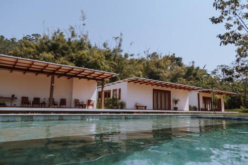 a villa with a swimming pool in front of a house at Fazenda Santa Vitória in Queluz