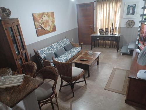 ein Wohnzimmer mit einem Sofa, Stühlen und einem Tisch in der Unterkunft Sobrado novo in Florianópolis