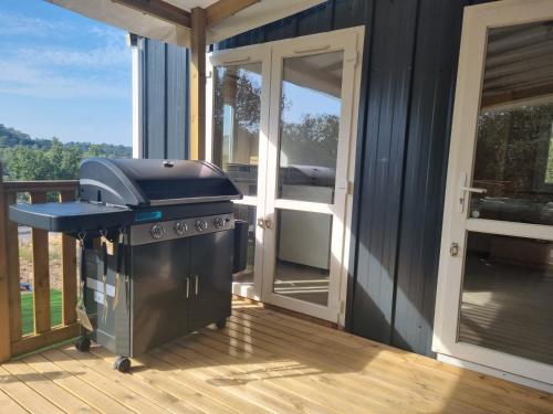 a grill on the deck of a house at Charmant et Spacieux Mobil Home in Rocbaron