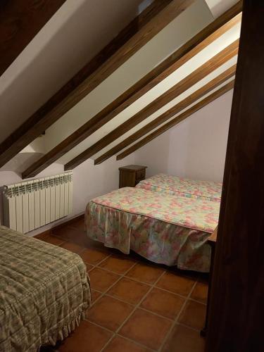 a bedroom with two beds in a attic at Albergue Rural Gorillo in Gor