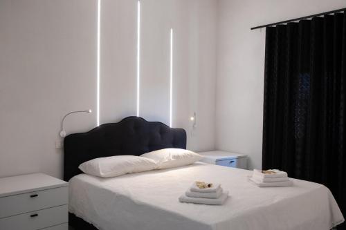 1 dormitorio con 1 cama con 2 toallas en Black & White, en Pietra Montecorvino