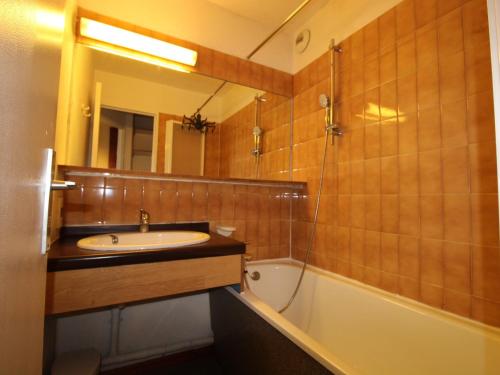 een badkamer met een wastafel, een bad en een spiegel bij Appartement Avoriaz, 2 pièces, 5 personnes - FR-1-633-60 in Morzine