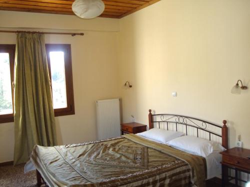 sypialnia z łóżkiem i oknem w obiekcie Guest House Pantos Kairou w mieście Karkaloú
