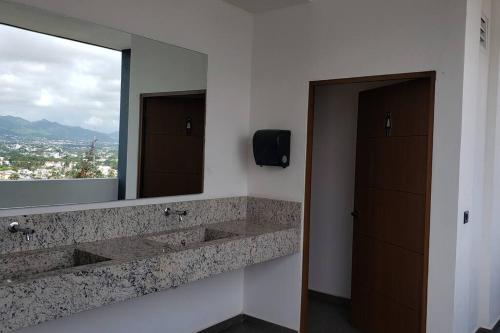 a bathroom with two sinks and a large mirror at ¡Hermoso Condo con espectacular vista a la bahia!! in Puerto Vallarta