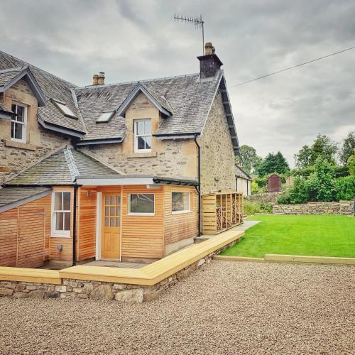 a house with a large deck in front of it at Laburnam Villa - Luxury 4 bedroom accommodation in the heart of Killin in Killin