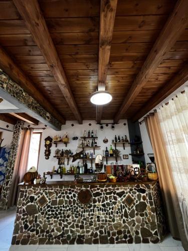 Habitación con una pared de piedra con estanterías en la pared en Guest House Aprripe Guri, en Fierzë