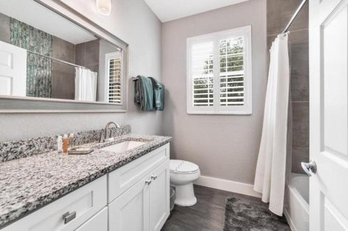 een badkamer met een wastafel, een toilet en een spiegel bij Windsor Hills Resort 3 Bedroom Condo 5 Minutes to Disney in Orlando