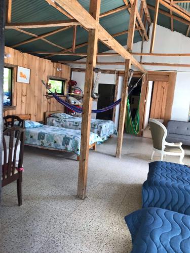 a room with two beds and a hammock in it at CABAÑA EN LA MONTAÑA in Macanal