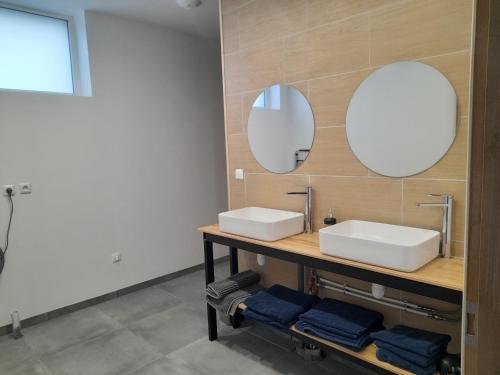 a bathroom with two sinks and two mirrors at Le domaine de l'Ebenne in Englefontaine