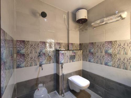 een badkamer met een douche en een toilet. bij Jazzy Beach Guest House in Visakhapatnam