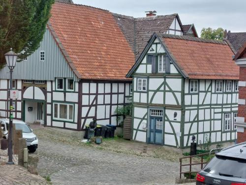 une rangée de bâtiments blancs et noirs avec des toits rouges dans l'établissement SCHNECKENHAUS, à Schieder-Schwalenberg