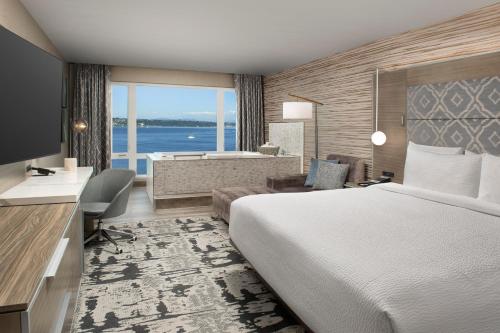 Silver Cloud Hotel Tacoma at Point Ruston Waterfront في تاكوما: غرفة في الفندق مع سرير وحوض استحمام