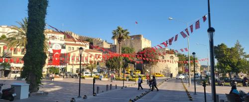 a city street with flags and people walking on the street at Picasso Suites Çeşme in Çeşme
