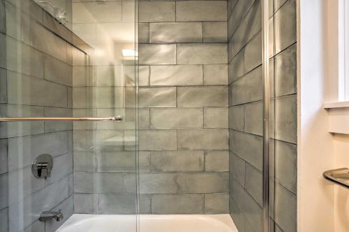 a shower with a glass door next to a tub at The Glabin Garrison Gem with Deck and Fire Pit! in Garrison