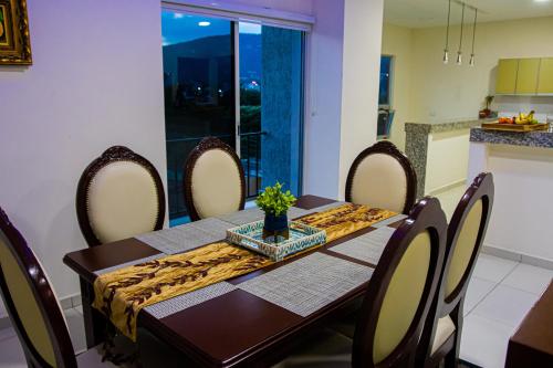 a dining room with a table with chairs and a table and a table at City Views Apartment in San Salvador