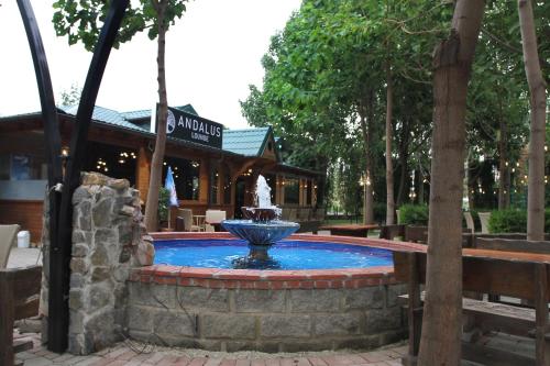 una fuente en medio de una piscina en un parque en Hotel Andalus, en Skopje