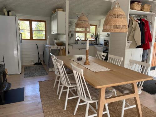 een keuken en eetkamer met een houten tafel en stoelen bij Holiday home VäTö IV in Harg