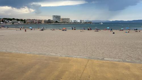 een groep mensen op een strand met de oceaan bij Apartamento en la playa. Free Parking. Free WiFi in L'Escala
