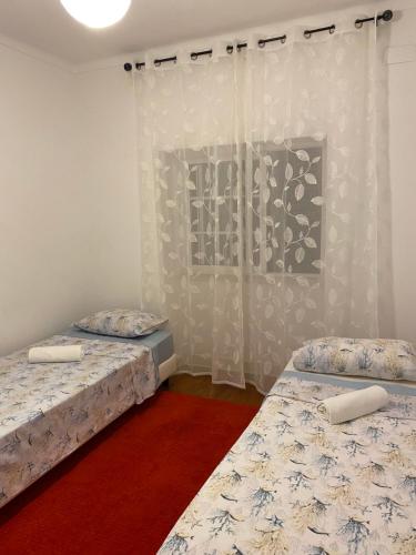 twee bedden in een kamer met witte muren bij Travelers House in Setúbal
