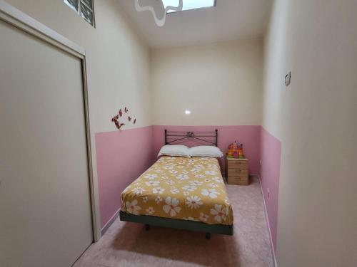 ナポリにあるCasa Principe di Napoliのピンクの壁の小さなベッドルーム(ベッド1台付)