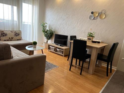 een woonkamer met een tafel en een televisie bij Delete 4 in Novi Grad