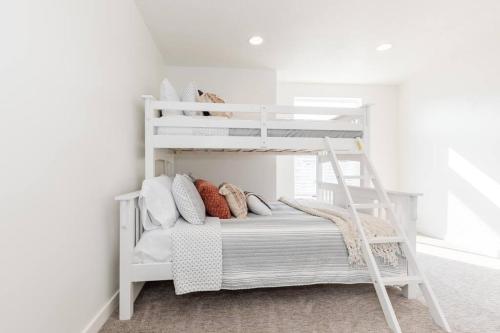 a white bunk bed in a white room with pillows at Bear Lake Beautiful Brand New End Unit in Garden City