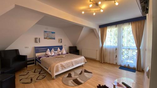 a bedroom with a bed and a large window at Casa Fanel in Buşteni