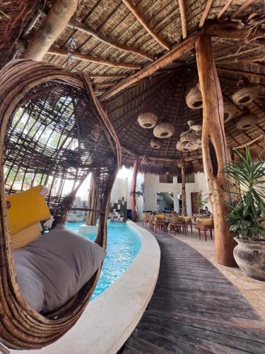 a hammock by a swimming pool in a resort at Xkeban Tulum Adults Only in Tulum