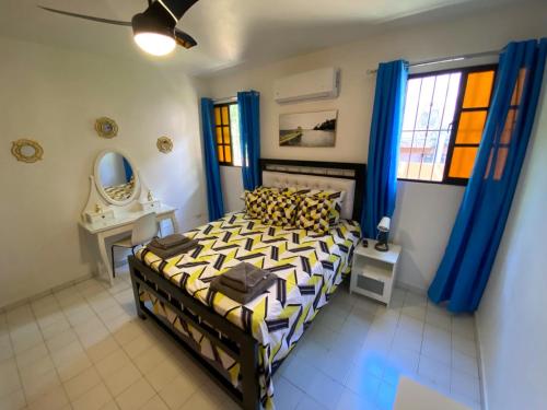 - une chambre avec un lit, un miroir et des rideaux bleus dans l'établissement Casa Corona Plaza, à Santiago de los Caballeros