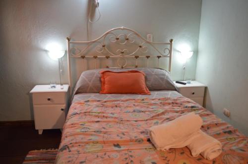 1 cama con almohada naranja y 2 mesitas de noche en Lo de Annie en Posadas