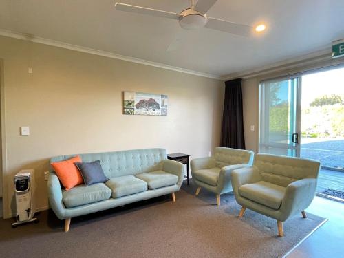a living room with a couch and two chairs at Pacific Park Christian Holiday Camp in Papamoa