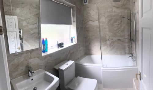 a bathroom with a toilet and a sink and a shower at Air Host in Walsall