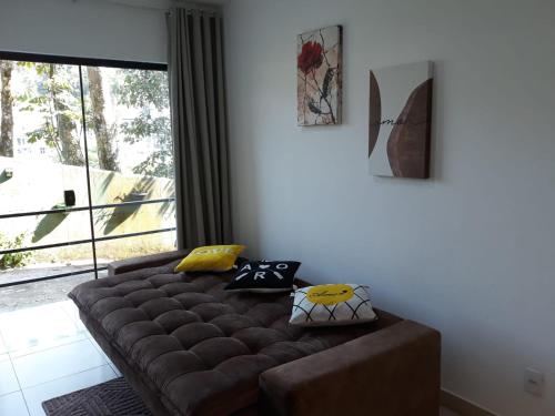 a brown couch in a living room with a window at Aconchego Serra Imperial-101 in Petrópolis