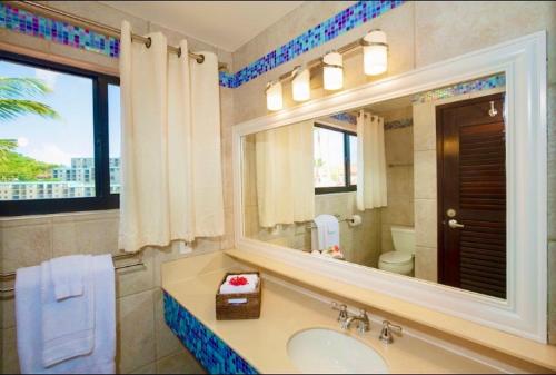 La salle de bains est pourvue d'un lavabo et d'un grand miroir. dans l'établissement Sapphire Beachfront Renovated Villa 1200 SF! - Free Wi-Fi, à East End