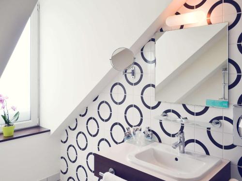 a bathroom with a sink and a mirror at Mercure Strasbourg Centre Gare in Strasbourg