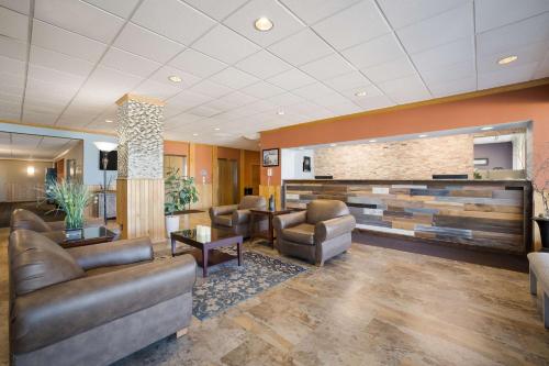 a lobby with leather furniture and a brick wall at Best Western Riverfront Inn in Marinette
