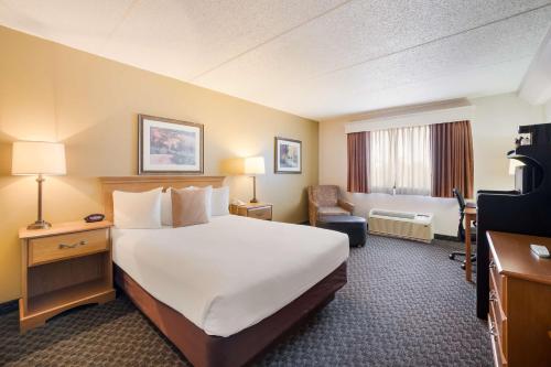 una habitación de hotel con una cama grande y una silla en Best Western Riverfront Inn, en Marinette