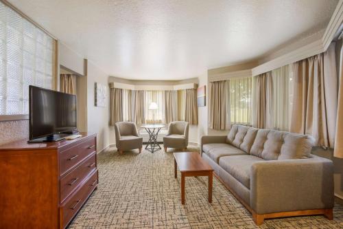 a living room with a couch and a flat screen tv at Best Western Harbour Pointe Lakefront in Saint Ignace