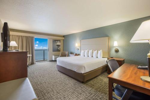 um grande quarto de hotel com uma cama e uma secretária em Best Western Harbour Pointe Lakefront em Saint Ignace
