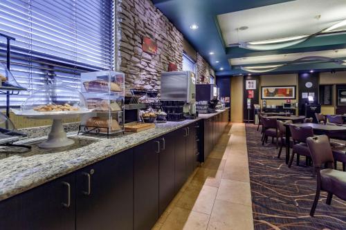 a restaurant with a buffet line with tables and chairs at Best Western Plus St Albert in St. Albert