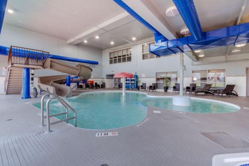 a swimming pool with a slide in a large room at Best Western Plus Eastgate Inn & Suites in Regina
