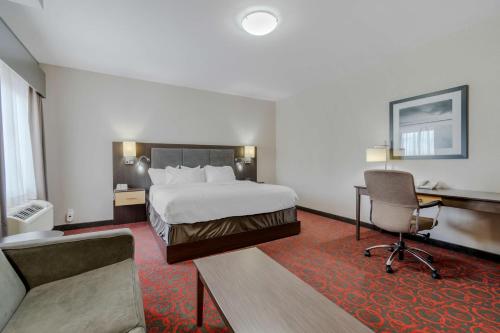 a hotel room with a bed and a desk and a chair at Best Western Plus Eastgate Inn & Suites in Regina