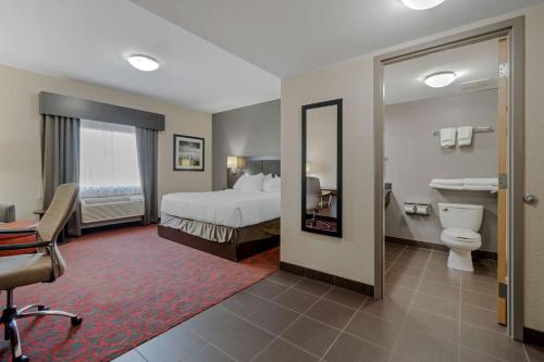 a hotel room with a bed and a toilet at Best Western Plus Eastgate Inn & Suites in Regina