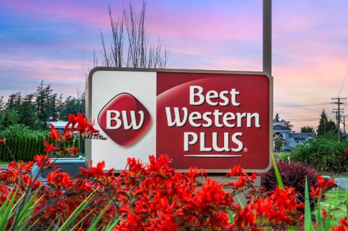 un panneau indiquant le meilleur occidental plus avec des fleurs rouges dans l'établissement Best Western Plus Bellingham, à Bellingham