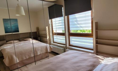 a bedroom with two beds and a mirror at Comfort Warszawa in Warsaw