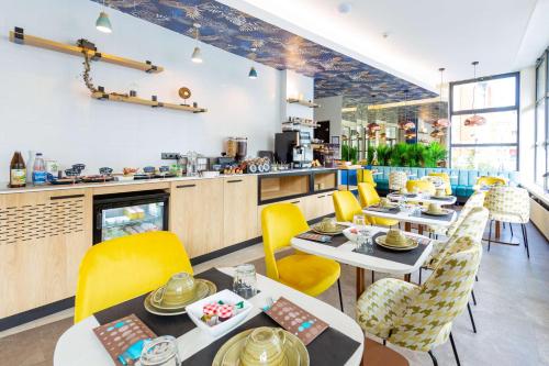une salle à manger avec des tables et des chaises jaunes dans l'établissement Best Western Mulhouse Salvator Centre, à Mulhouse