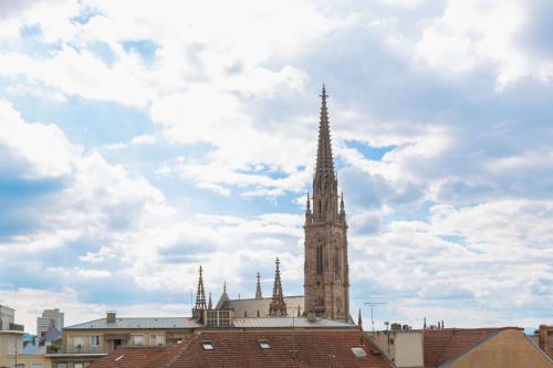 a tall steeple of a building with a sky at Best Western Mulhouse Salvator Centre in Mulhouse